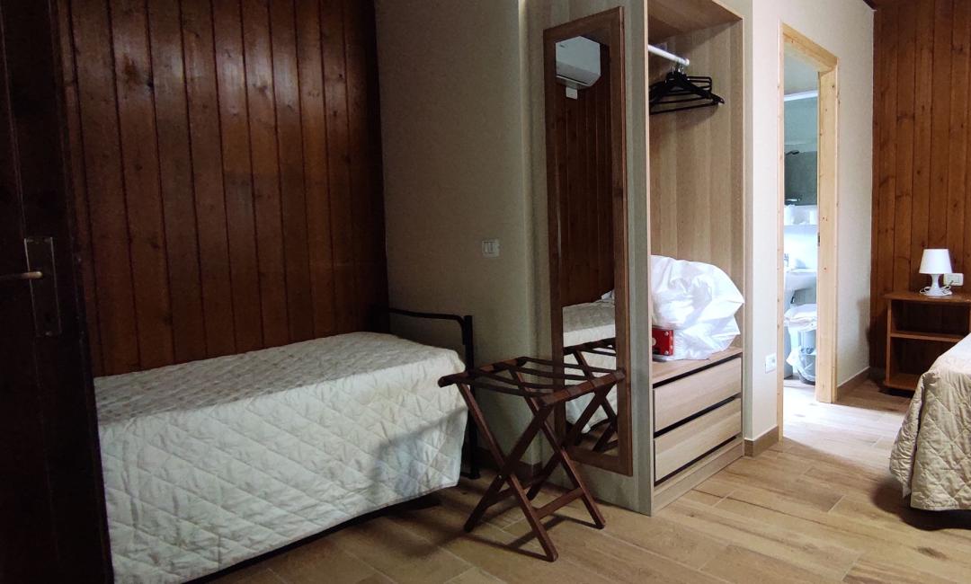 Camera accogliente con letti e pareti in legno, calda e rilassante.